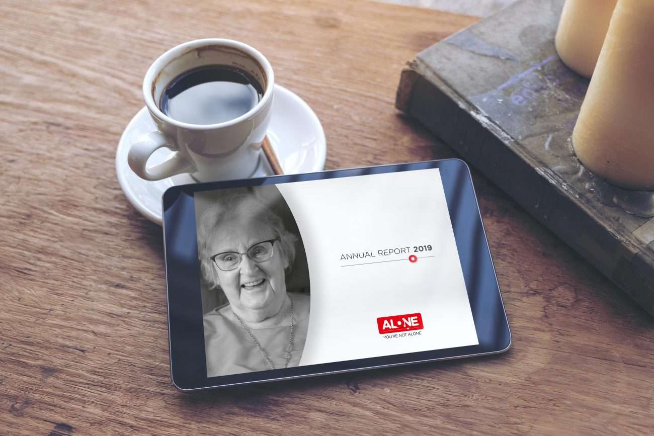 Top view mock up image of black tablet with white blank desktop screen and coffee cup , book , candles on vintage wooden table in cafe